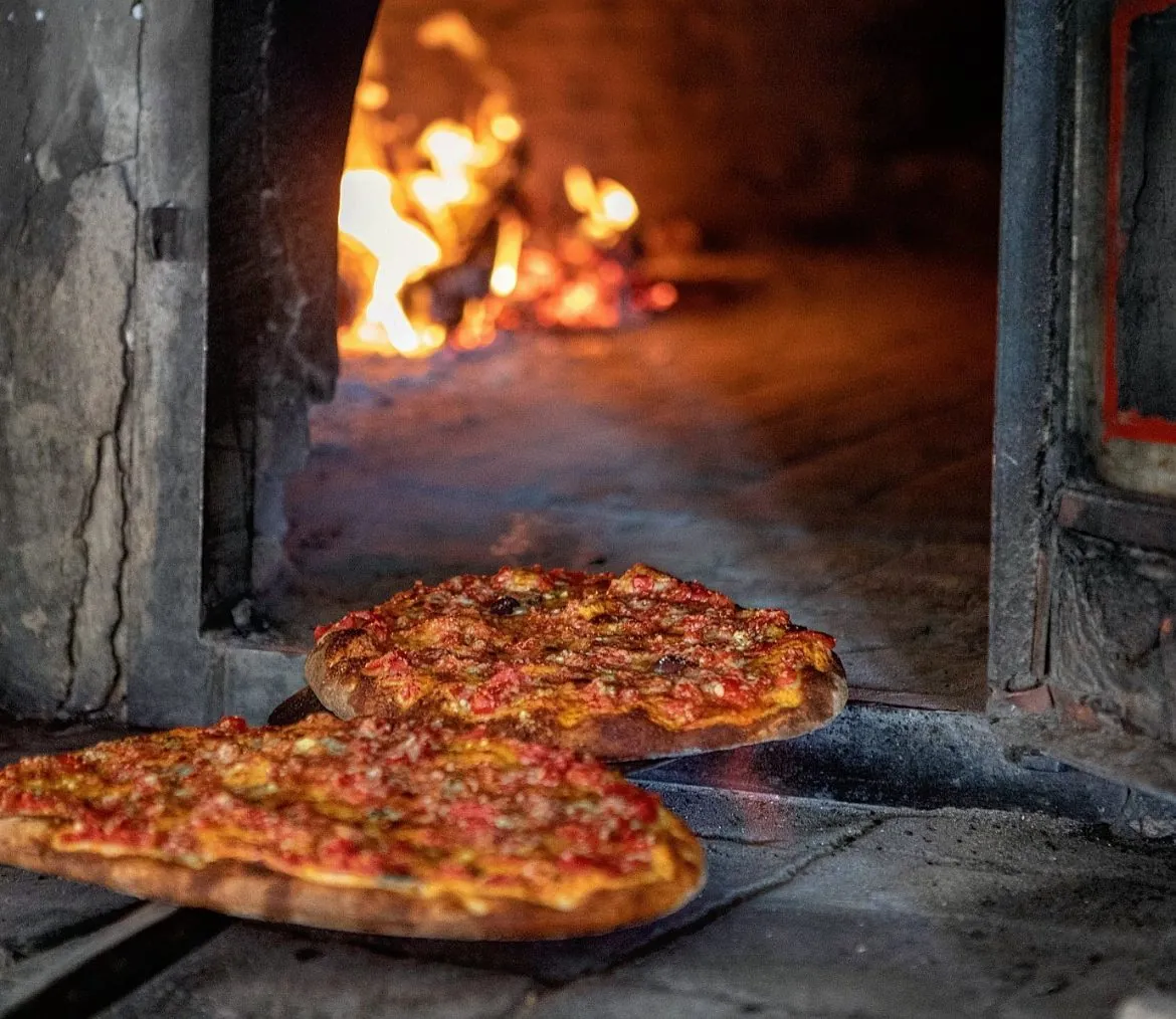 Le fàuzze appena sfornate davanti al fuoco del forno a pietra